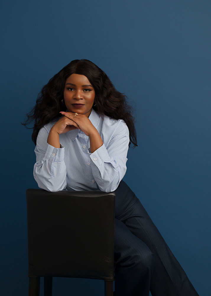 Professional portrait in a striped shirt against a blue backdrop