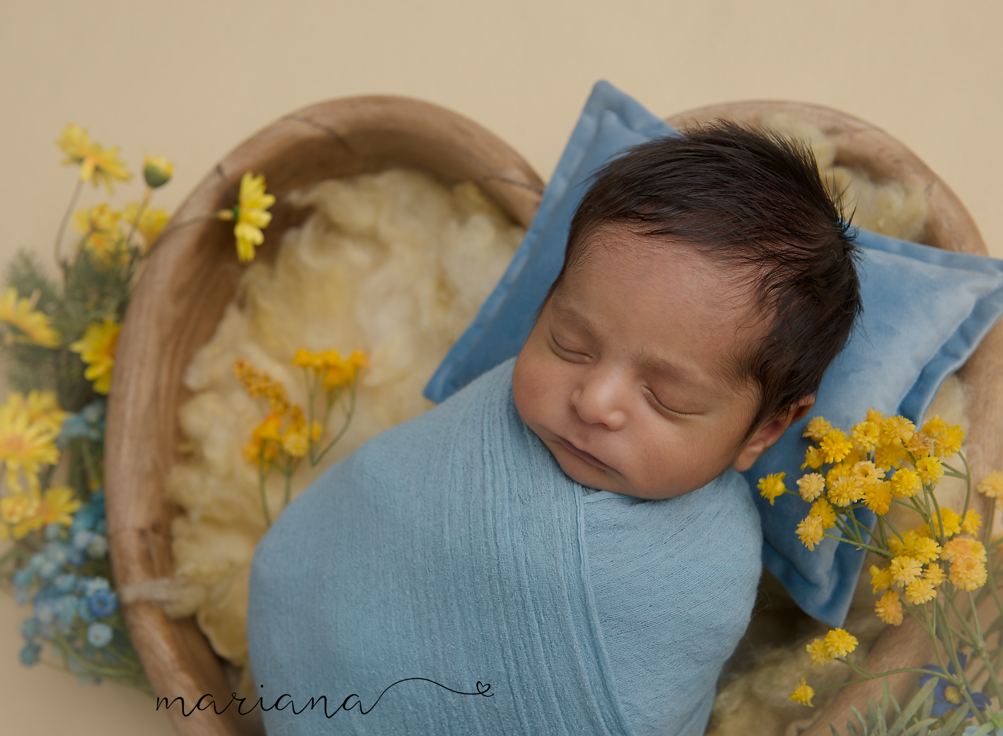 Newborn wrapped in blue with yellow flowers