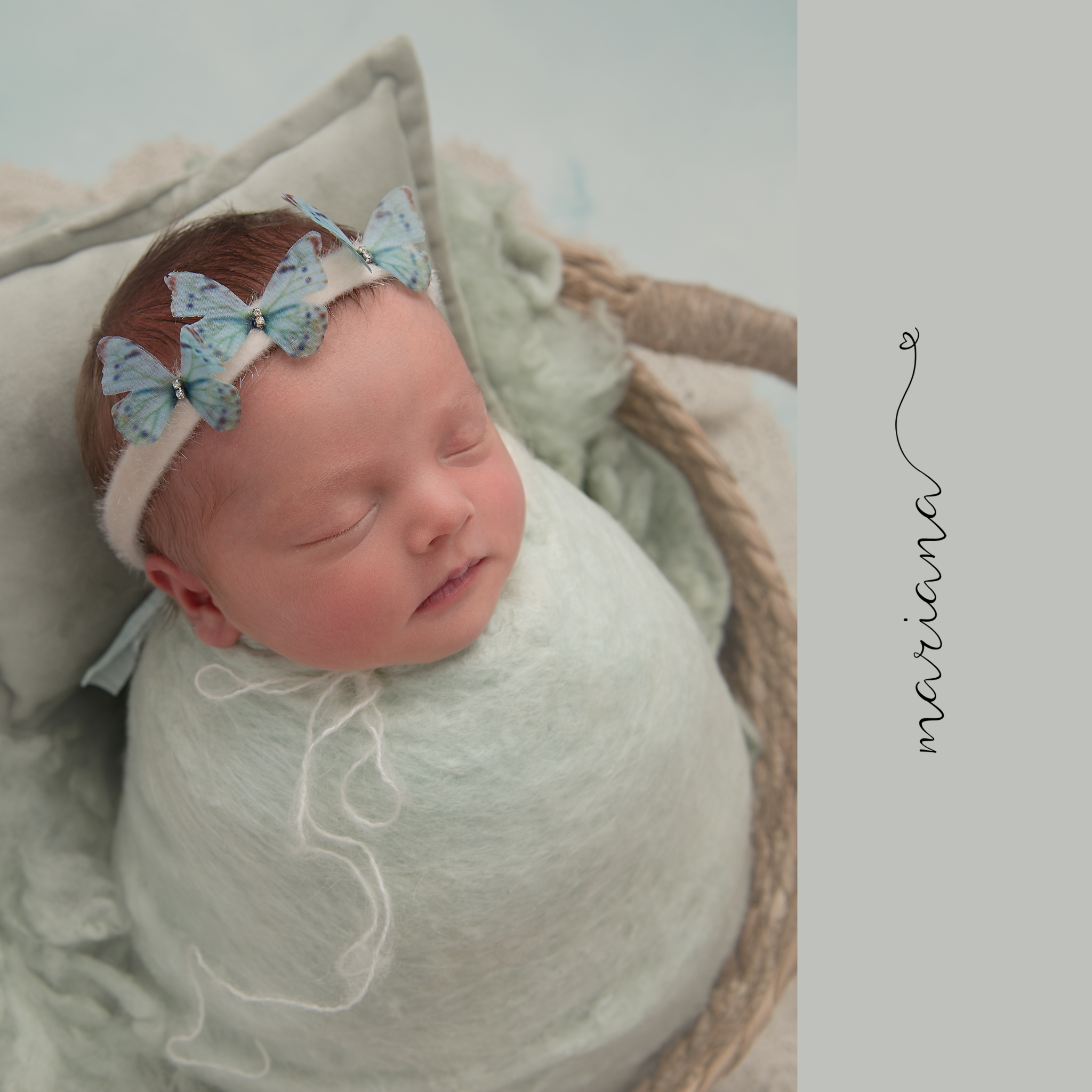 Sleeping newborn wrapped in pale mint with a delicate headband