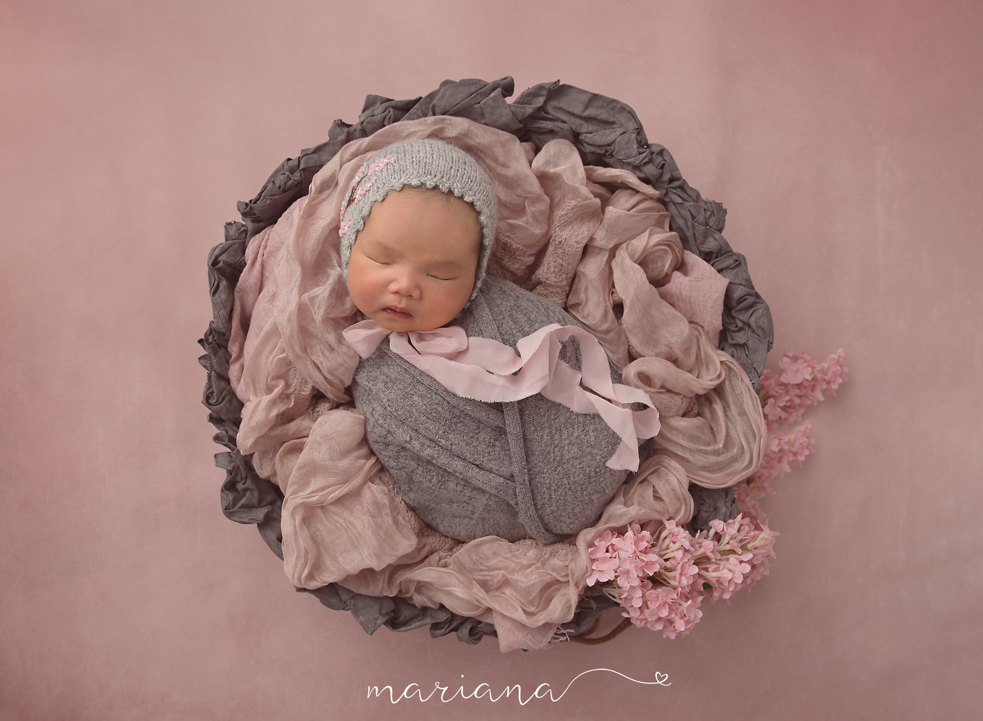 Sleeping newborn in pink and grey with soft floral details
