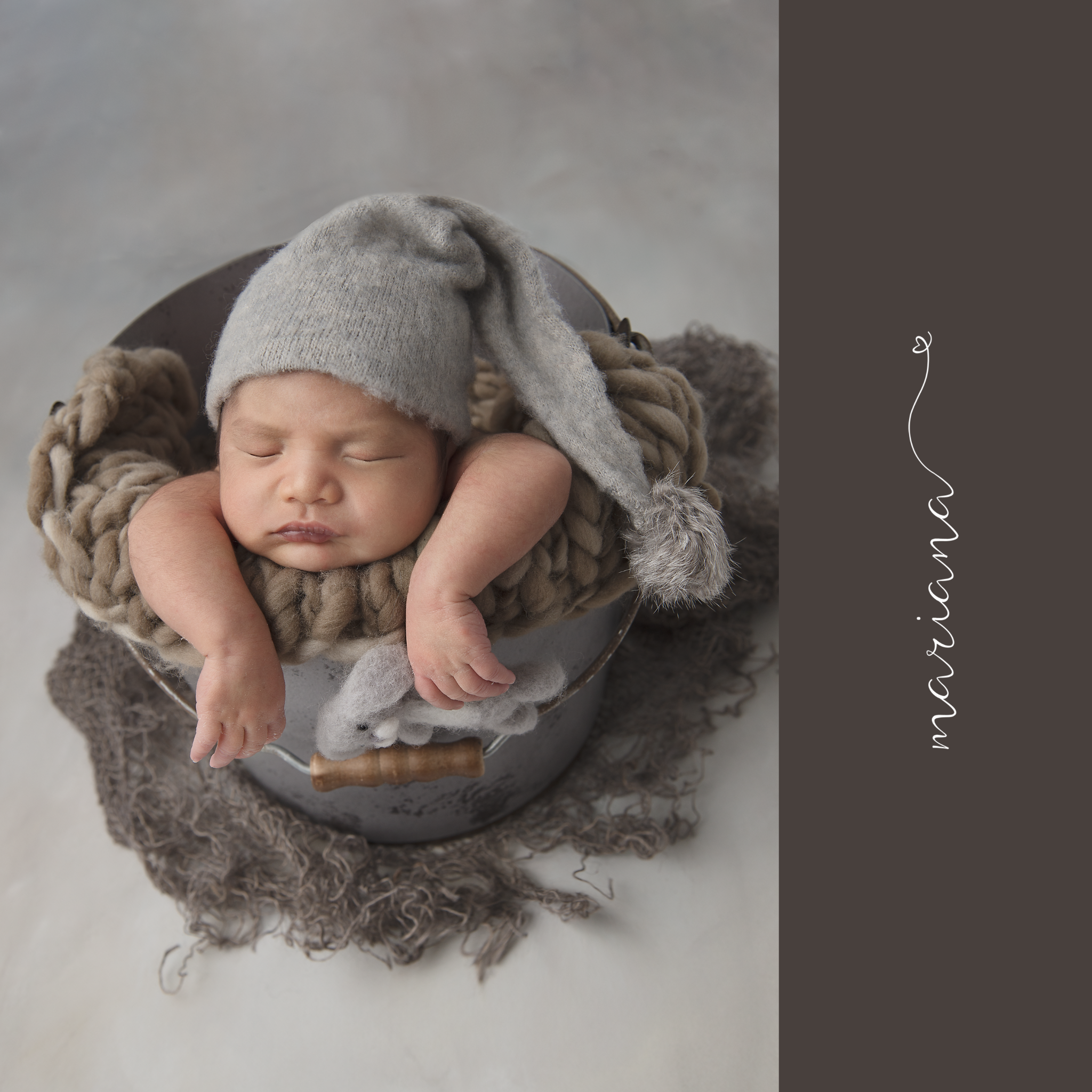 Sleeping newborn in a soft grey bonnet