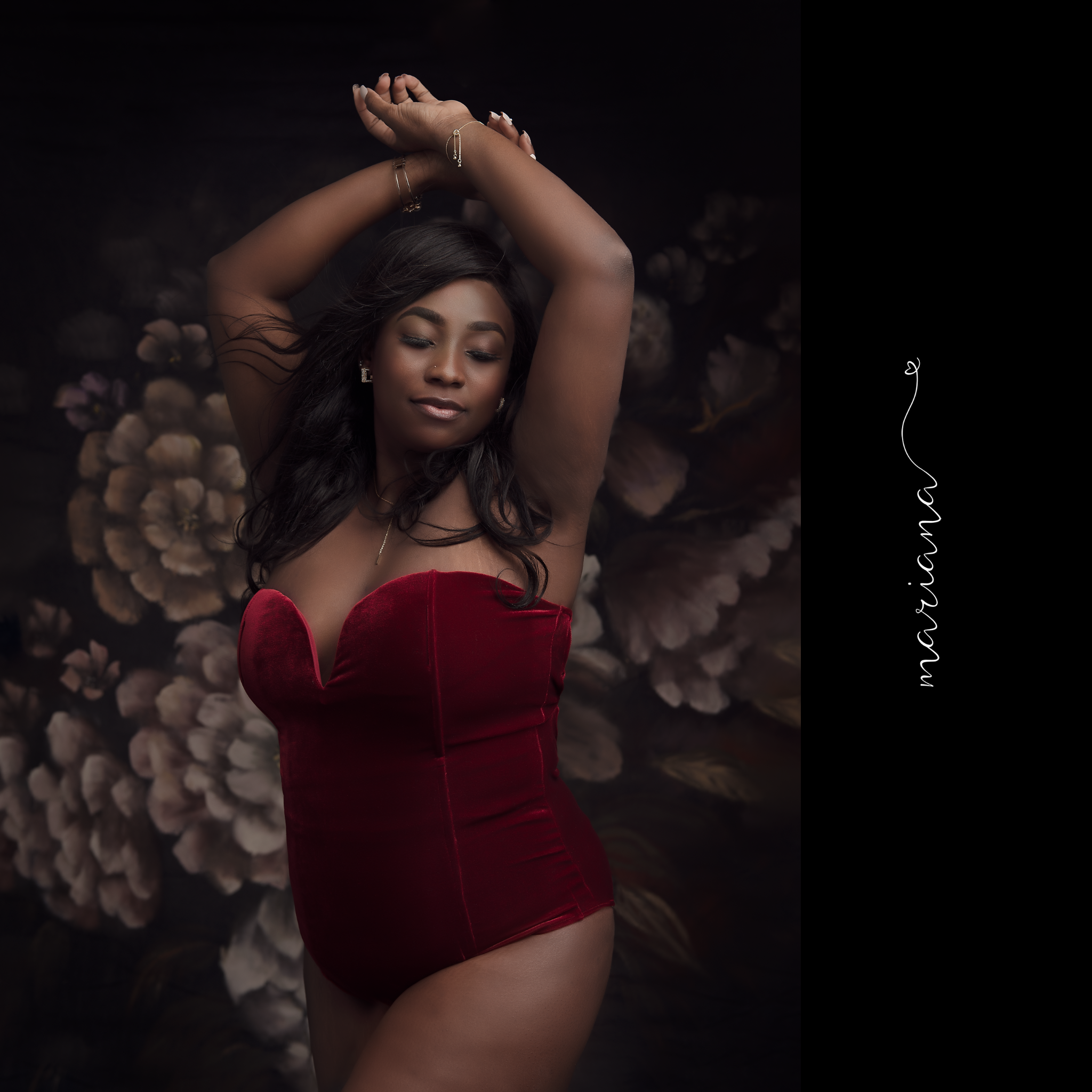 Glamour portrait in red velvet against a dark floral backdrop