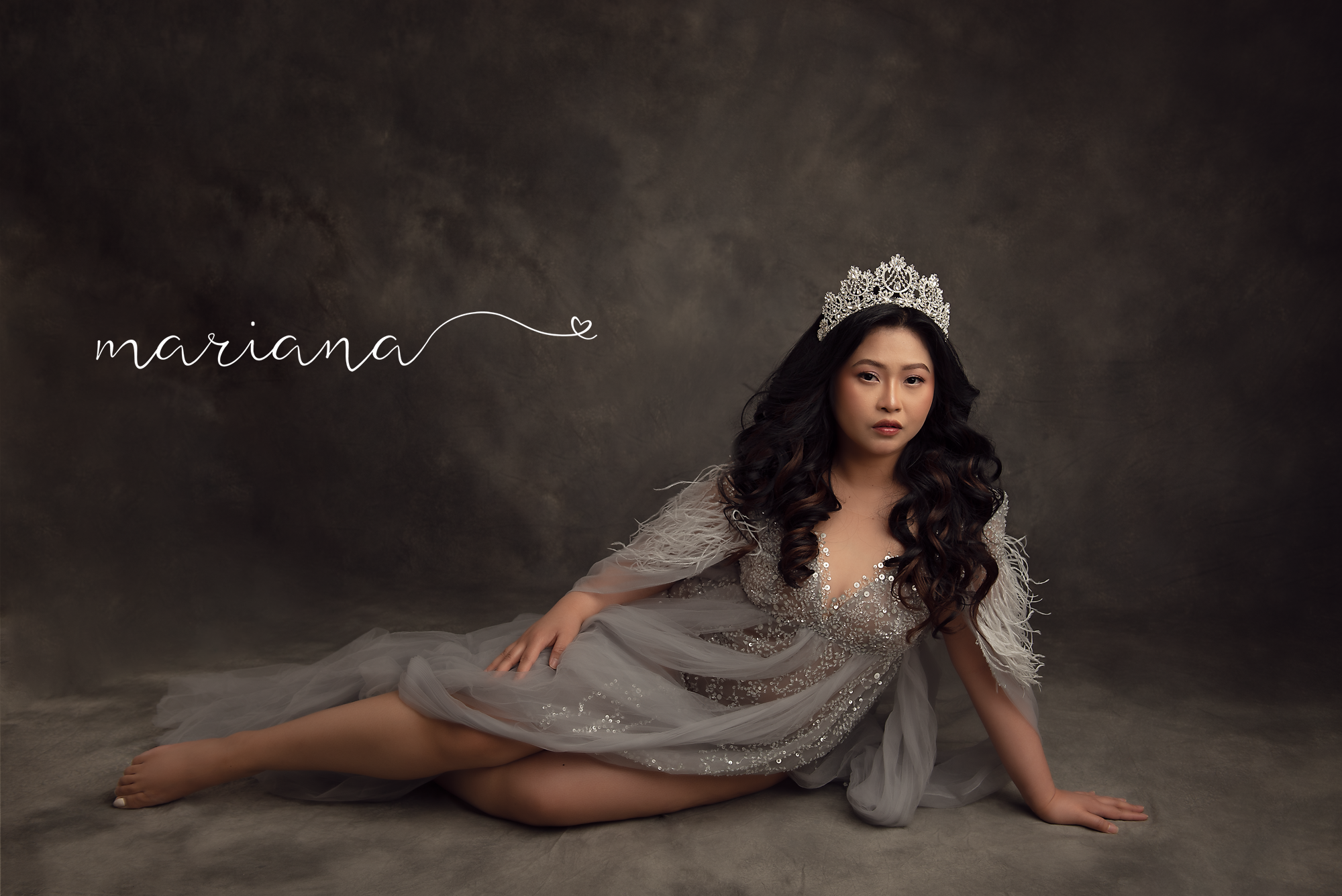 Reclining glamour portrait in a silver gown and crown
